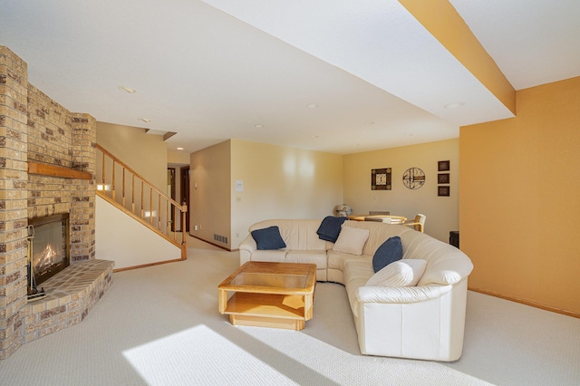 living room with baseboards, carpet, a brick fireplace, and stairs