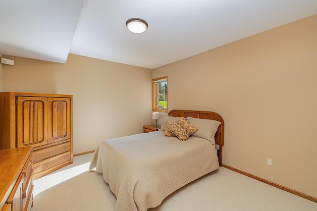 bedroom featuring baseboards and light carpet