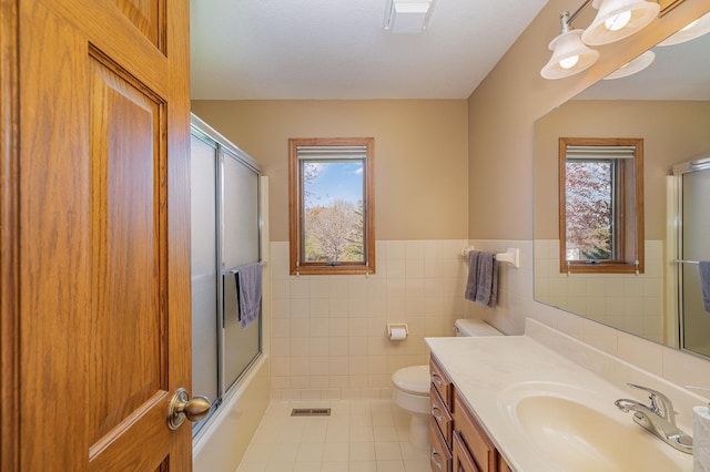 full bathroom featuring vanity, visible vents, tile patterned floors, toilet, and combined bath / shower with glass door