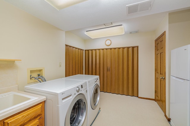 clothes washing area with washing machine and clothes dryer, visible vents, light colored carpet, and laundry area