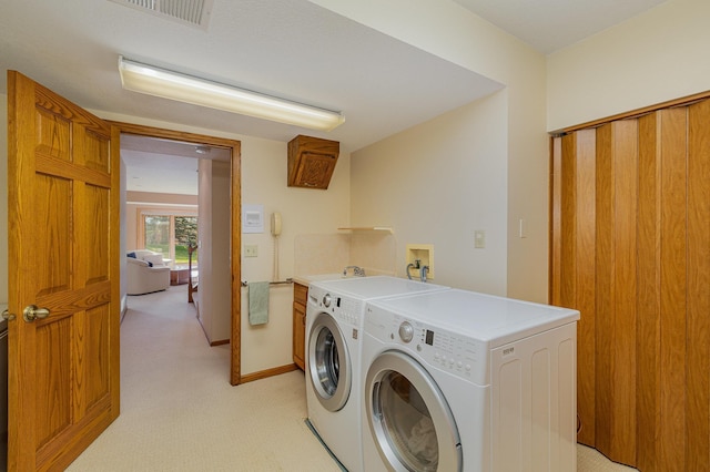 laundry room with visible vents, baseboards, cabinet space, washing machine and dryer, and light colored carpet