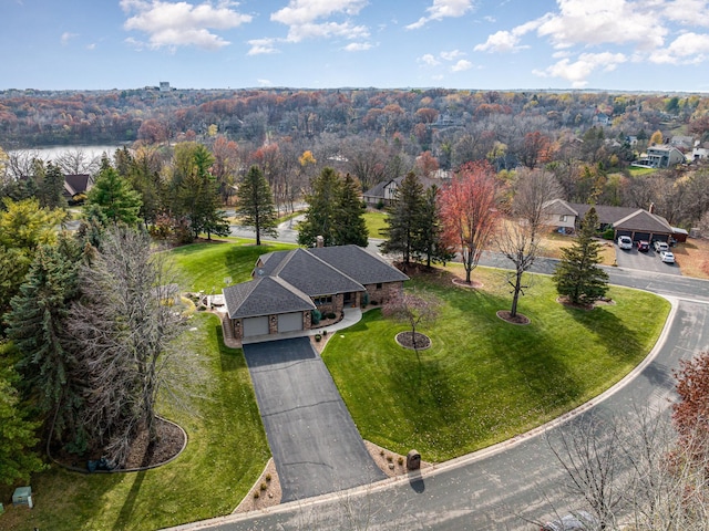 birds eye view of property with a view of trees and a water view