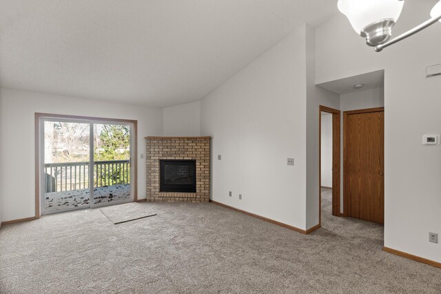 unfurnished living room featuring high vaulted ceiling, an inviting chandelier, carpet flooring, and a fireplace