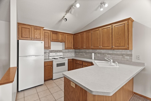 kitchen with kitchen peninsula, white appliances, sink, and lofted ceiling