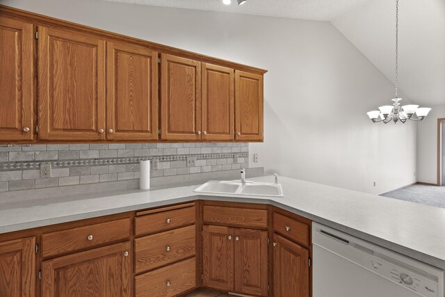 kitchen featuring a notable chandelier, white dishwasher, pendant lighting, sink, and vaulted ceiling