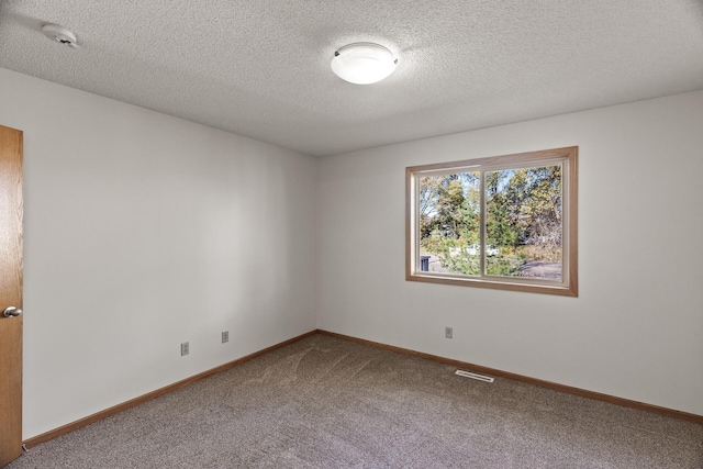 empty room with carpet and a textured ceiling