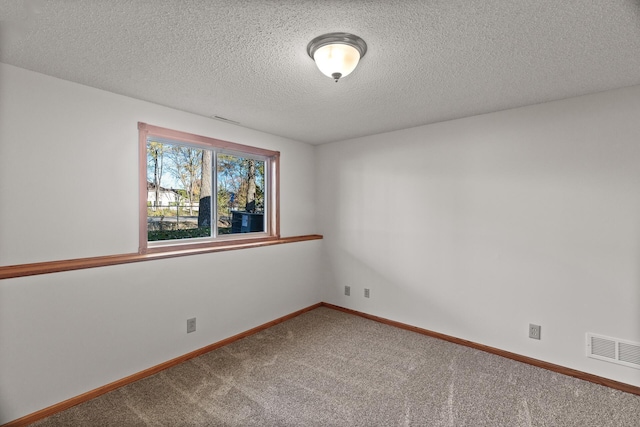 empty room with a textured ceiling and carpet floors