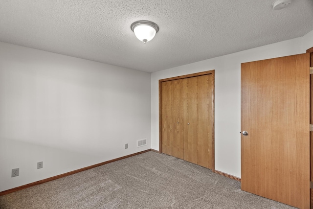 unfurnished bedroom with light colored carpet and a textured ceiling