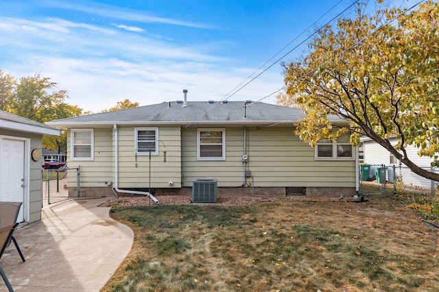 back of property with cooling unit, a yard, roof with shingles, and fence