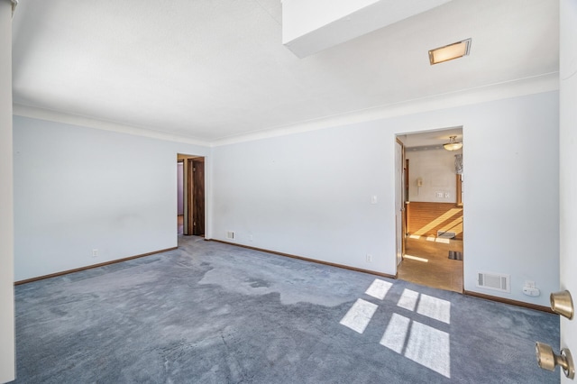 spare room featuring baseboards, visible vents, carpet floors, and ornamental molding