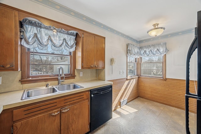 kitchen with a sink, light floors, black appliances, and light countertops