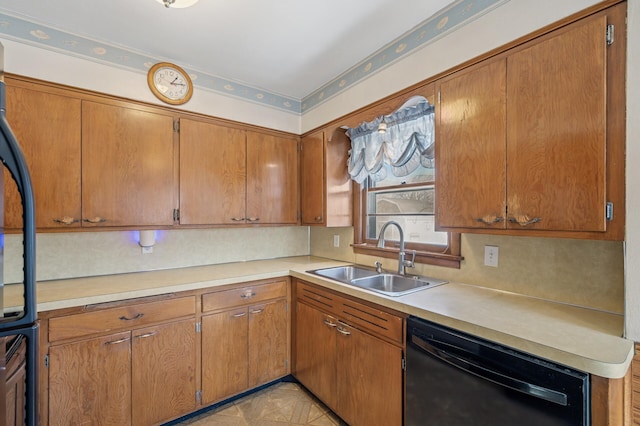 kitchen featuring black appliances, brown cabinetry, light countertops, and a sink