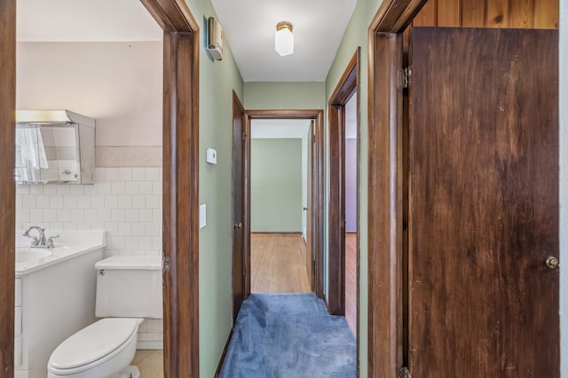 bathroom featuring toilet, tile walls, and vanity