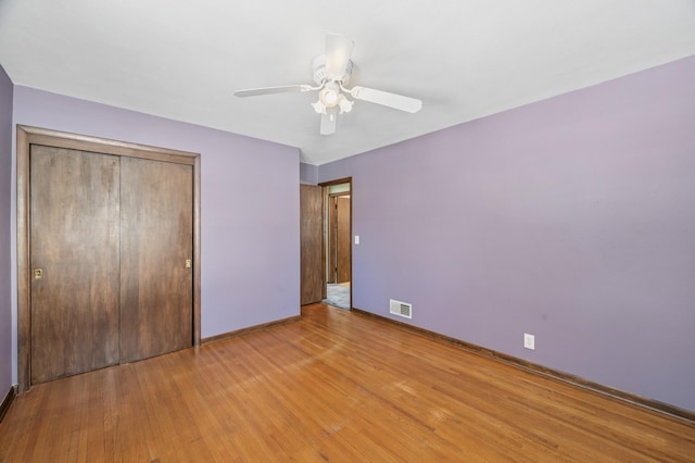 unfurnished bedroom with a closet, visible vents, baseboards, and light wood-style floors