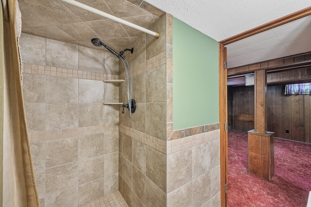 full bathroom with a textured ceiling and tiled shower