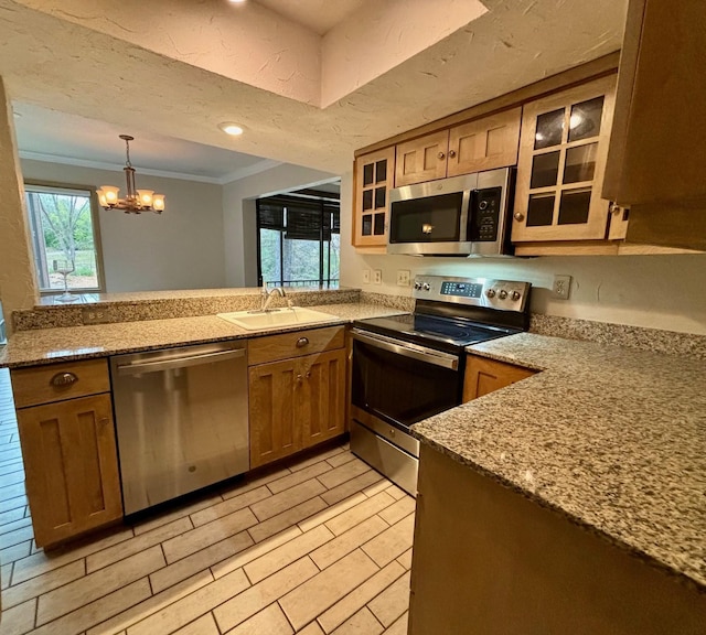 kitchen featuring appliances with stainless steel finishes, sink, light wood-type flooring, light stone counters, and ornamental molding