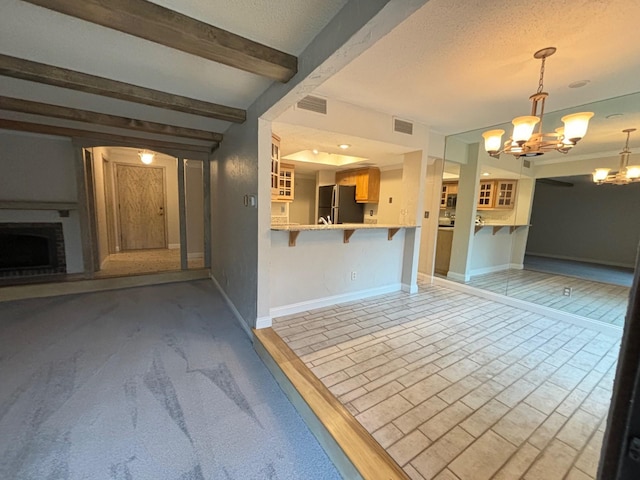 unfurnished living room featuring beam ceiling, a textured ceiling, and a chandelier