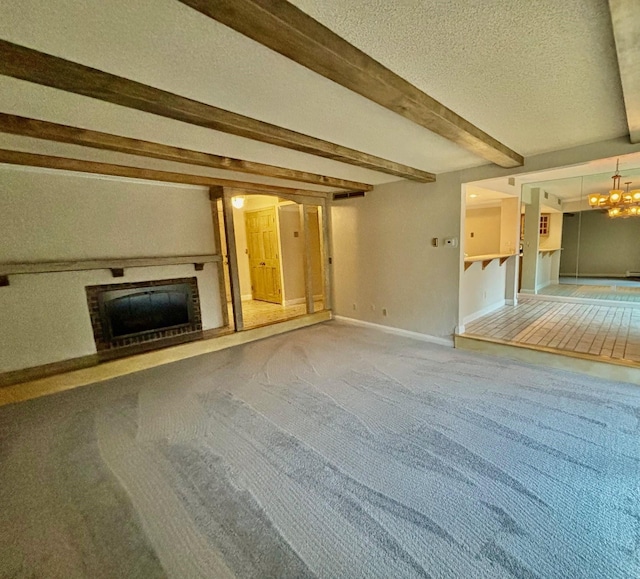 unfurnished living room featuring beam ceiling, a textured ceiling, and carpet flooring