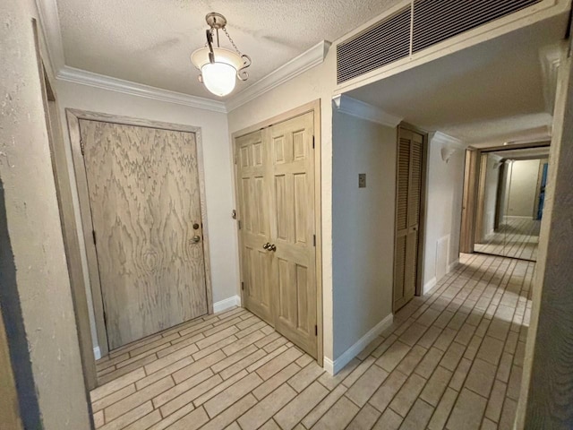 hallway featuring ornamental molding and a textured ceiling