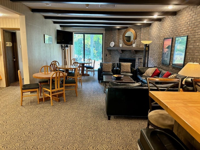 carpeted living room with beam ceiling, brick wall, and a brick fireplace