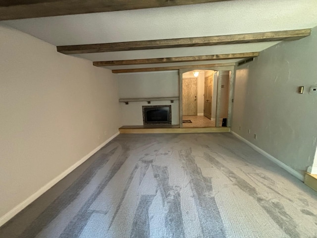 unfurnished living room with carpet flooring and beamed ceiling