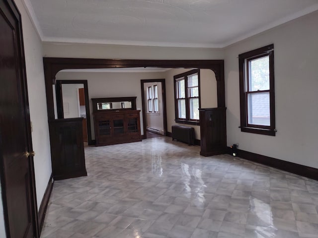 interior space with ornamental molding, a baseboard heating unit, and radiator