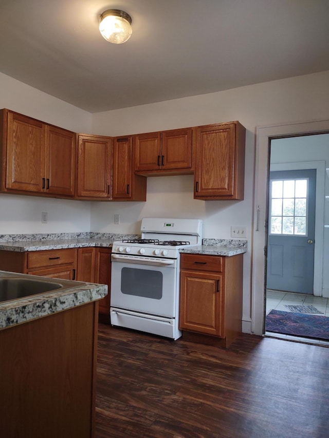 kitchen featuring dark wood-type flooring and gas range gas stove