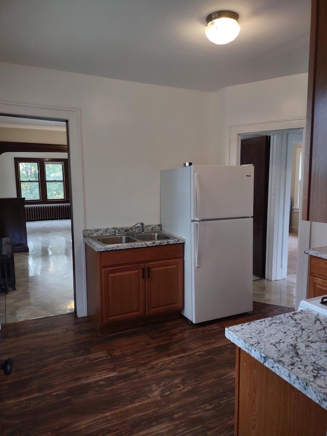 kitchen with sink, radiator, dark hardwood / wood-style floors, and white refrigerator