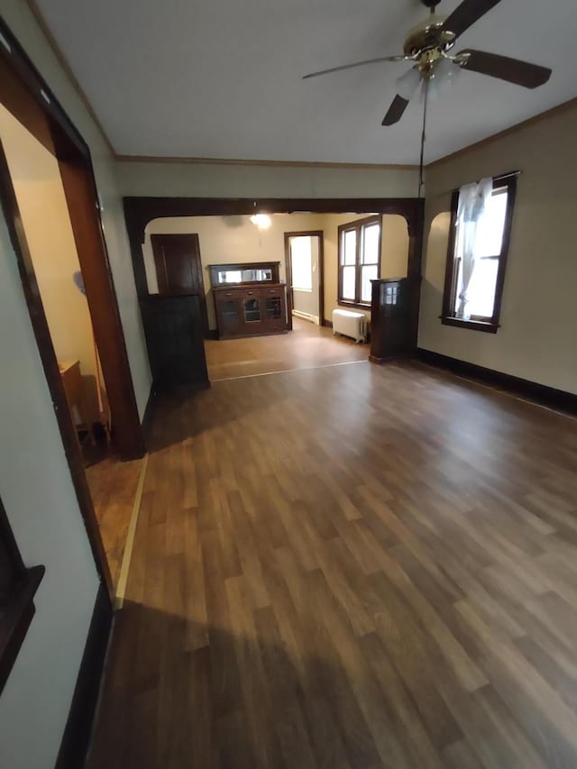 unfurnished living room with crown molding, dark hardwood / wood-style floors, and ceiling fan