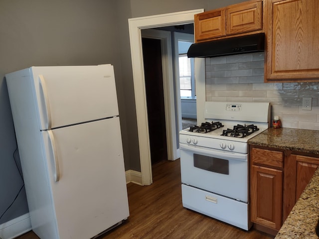 kitchen with stone counters, backsplash, dark hardwood / wood-style floors, and white appliances