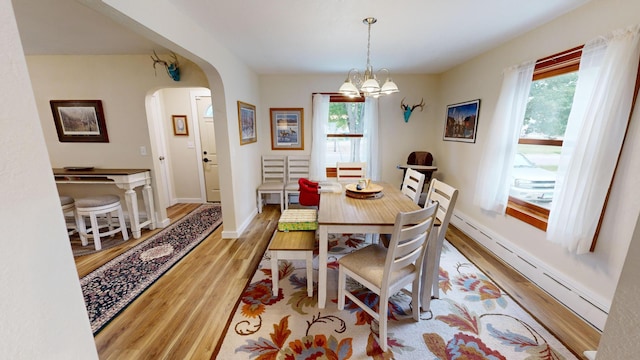 dining space featuring light hardwood / wood-style floors, a notable chandelier, and a baseboard radiator