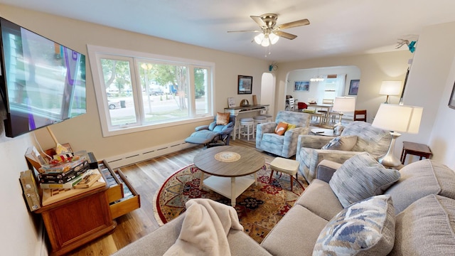 living room featuring a baseboard radiator, light hardwood / wood-style floors, and ceiling fan