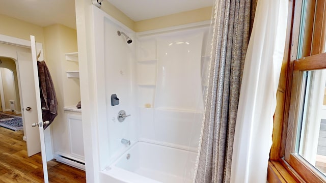 bathroom with shower / bath combo with shower curtain, baseboard heating, and wood-type flooring