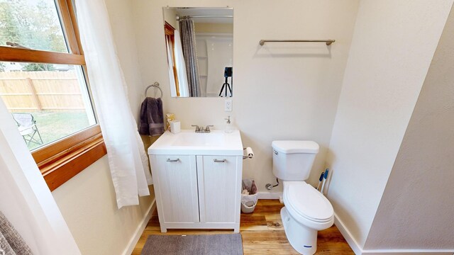 bathroom featuring toilet, hardwood / wood-style flooring, and vanity