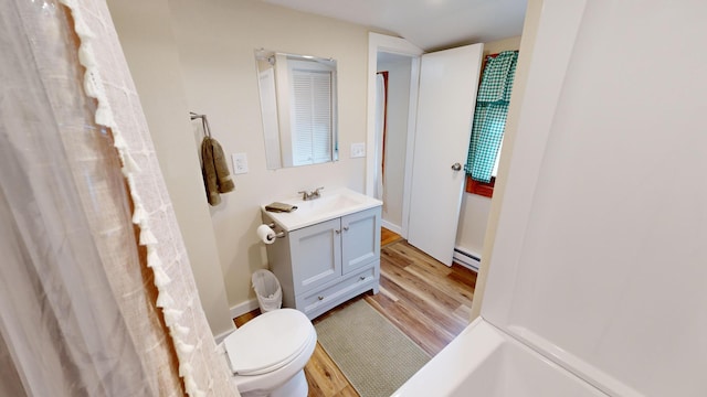 bathroom featuring hardwood / wood-style flooring, toilet, a baseboard heating unit, vanity, and walk in shower