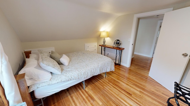 bedroom with light hardwood / wood-style floors and vaulted ceiling