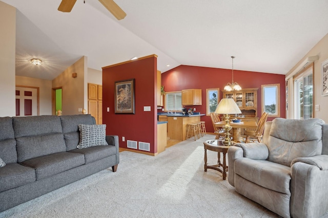 living area featuring lofted ceiling, ceiling fan with notable chandelier, visible vents, and light colored carpet