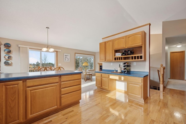 kitchen with dark countertops, decorative light fixtures, light wood-style flooring, and open shelves