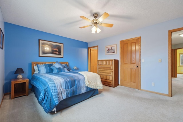 carpeted bedroom featuring a textured ceiling, baseboards, and a ceiling fan