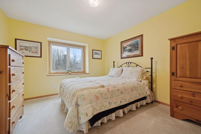 bedroom with light carpet, baseboards, and a textured ceiling