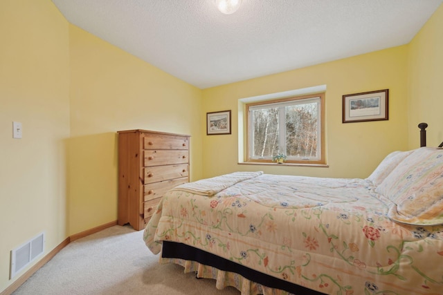 bedroom with carpet, a textured ceiling, visible vents, and baseboards