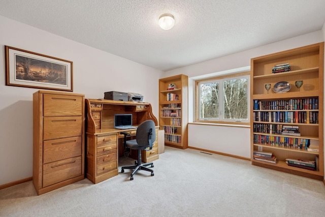 office area featuring visible vents, baseboards, a textured ceiling, and light colored carpet