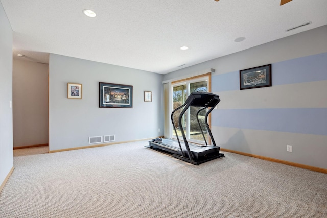 exercise room featuring carpet floors, visible vents, and baseboards