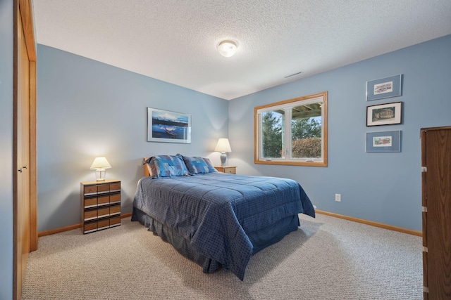 carpeted bedroom featuring visible vents, baseboards, and a textured ceiling