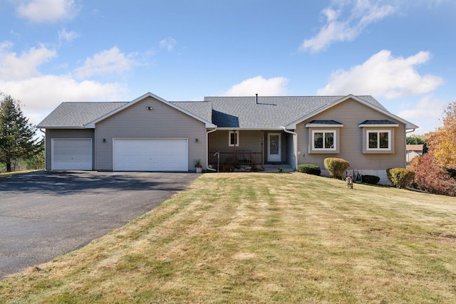 ranch-style house featuring roof with shingles, covered porch, a garage, driveway, and a front lawn