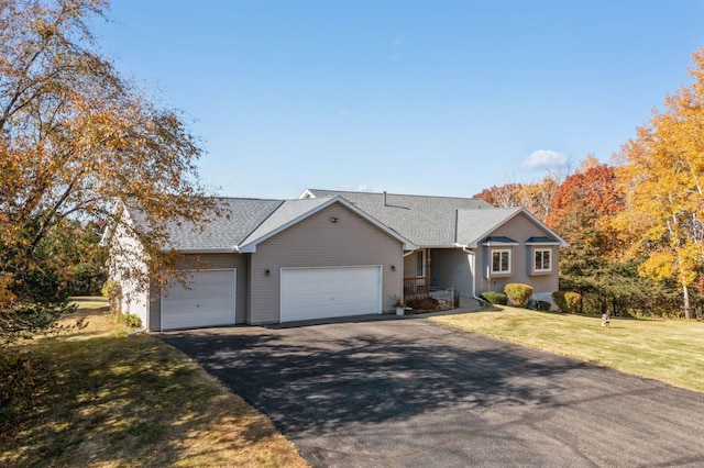 ranch-style home featuring a garage, driveway, a front lawn, and a shingled roof