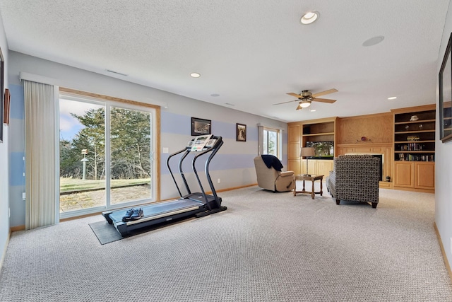 exercise room featuring recessed lighting, a textured ceiling, and light colored carpet