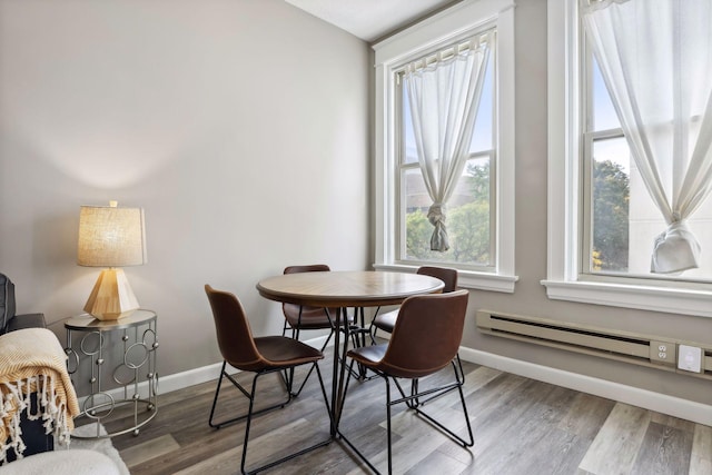 dining space with a baseboard radiator and hardwood / wood-style floors