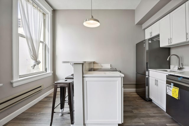 kitchen featuring dishwasher, a baseboard heating unit, sink, decorative light fixtures, and white cabinetry