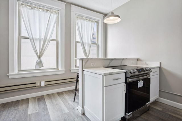 kitchen with white cabinets, decorative light fixtures, a wealth of natural light, and electric stove